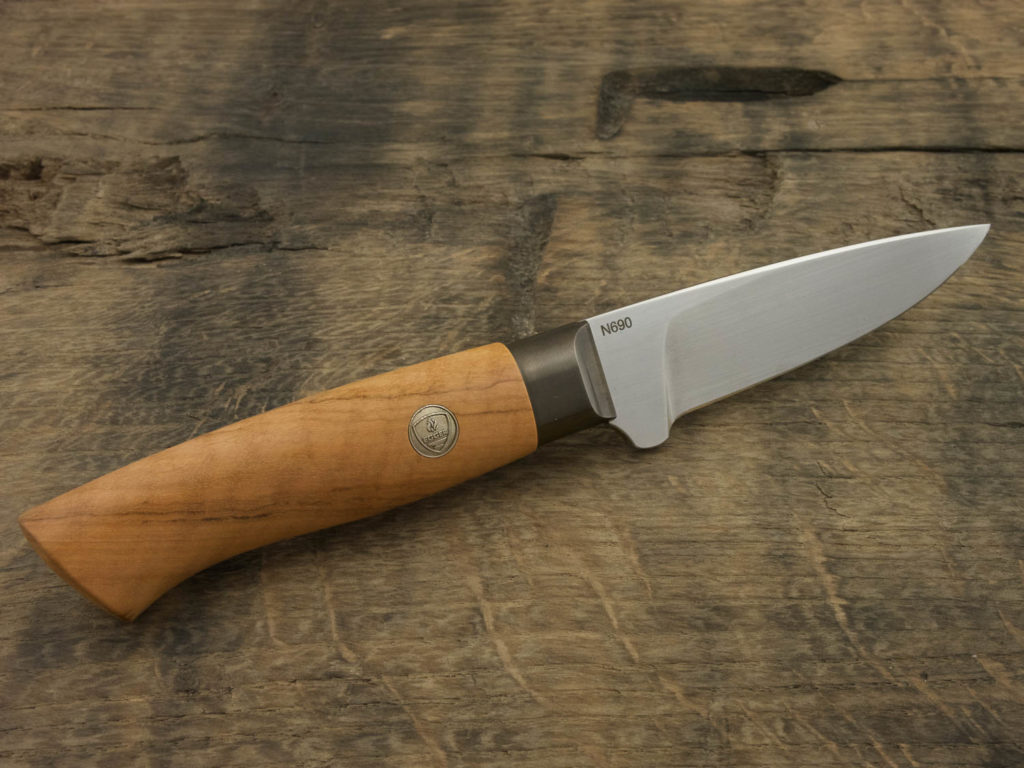 J055-9 Outdoor knife with Olive wood handle presented on a piece of aged oak.