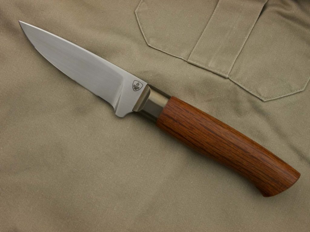 J056-3 A hand-forged hunting knife with a handle made of pockwood, a patinated bronze bolster, and a blade made of N690 steel.